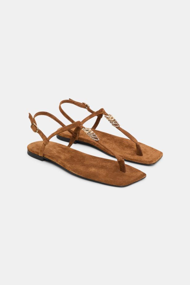 Ein Paar braune Zehentrenner-Sandalen mit Schmuckdetails.