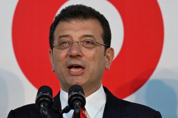 FILES-FRANCE-TURKEY-POLITICS Ekrem İmamoğlu spricht vor einem roten und weißen Hintergrund.