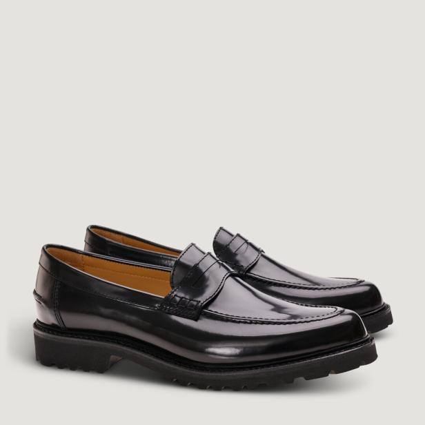 Zwei schwarze Penny Loafer aus Leder stehen nebeneinander.