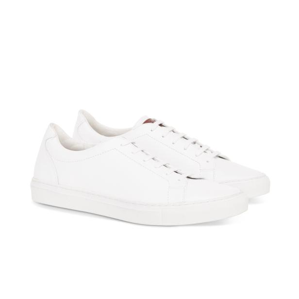 Ein Paar weiße Ledersneakers stehen auf einem weißen Hintergrund.