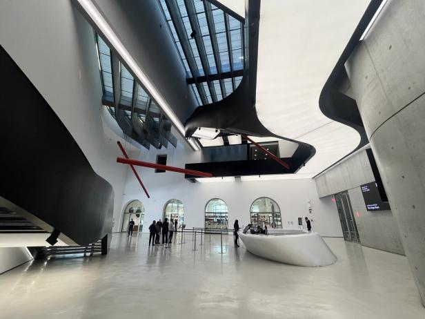 Das Innere eines modernen Museums mit geschwungenen Formen und einer roten Skulptur.