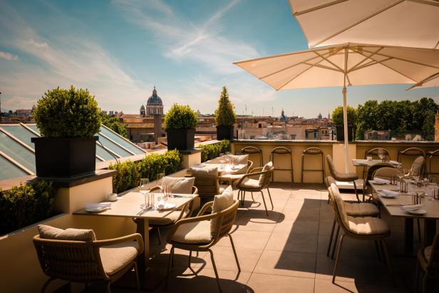 Ein Restaurant auf einer Dachterrasse mit Blick auf Rom.