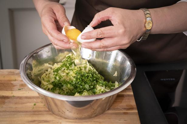 Ei mit Zucchini, Erdäpfel, Salz, Pfeffer und Muskat vermengen