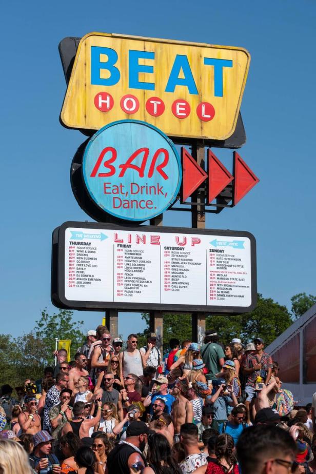 Menschenmenge vor einem Schild für das „Beat Hotel“ mit der Aufschrift „Bar, Eat, Drink, Dance“.