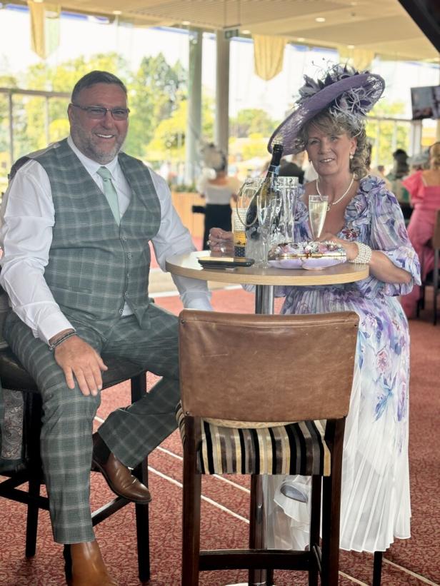 Ein Paar in eleganter Kleidung genießt Champagner beim Royal Ascot Pferderennen.