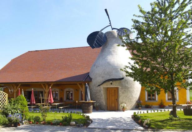 Ein gelbes Haus mit einer steinernen Birne im Eingangsbereich.
