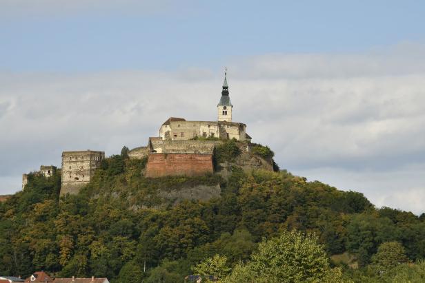 Die Burg Güssing thront auf einem bewaldeten Hügel im Burgenland, Österreich.