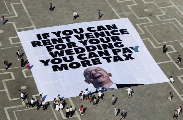 A large banner against Amazon founder Jeff Bezos lies on the ground in St. Mark's Square A large banner against Amazon founder Jeff Bezos lies on the ground in St. Mark's Square