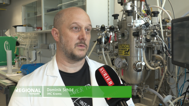 Ein Mann wird in einem Labor interviewt.