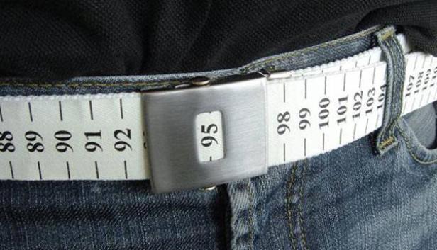 Eine Person trägt einen Gürtel, der wie ein Maßband aussieht, um ihre Jeans.