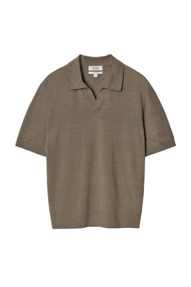 Ein khakifarbenes Poloshirt der Marke COS vor einem weißen Hintergrund.