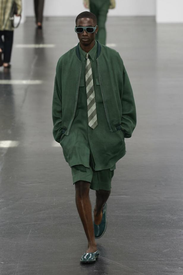 Ein Mann in einem grünen Fendi-Outfit läuft über den Laufsteg der Mailänder Modewoche Frühjahr/Sommer 2025.