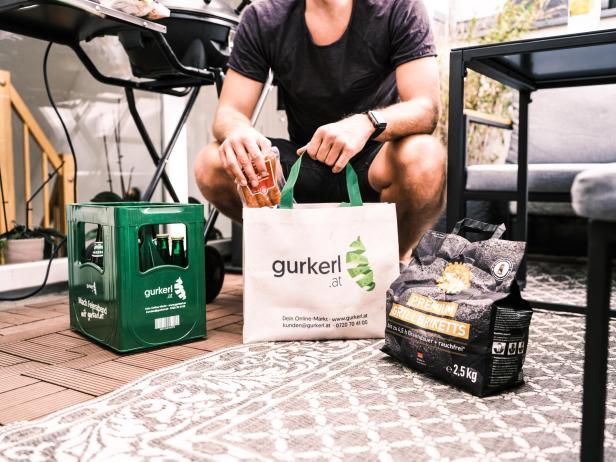 Ein Mann packt seine Einkäufe von gurkerl aus, inklusive seinem kühl gelieferten Bier. 