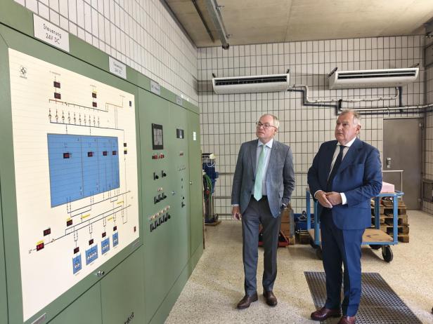 Zwei Männer stehen vor einer Schalttafel mit dem Titel „EVN Wasser Ausbaustudie 2055“.