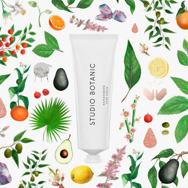 Eine Tube Handcreme von Studio Botanic ist von Früchten und Blättern umgeben.