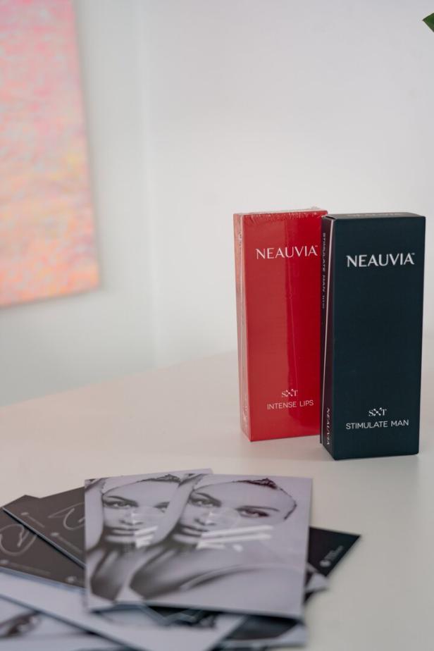 Eine rote Packung „Neauvia Intense Lips“ und eine schwarze Packung „Neauvia Stimulate Man“ stehen auf einem Tisch.