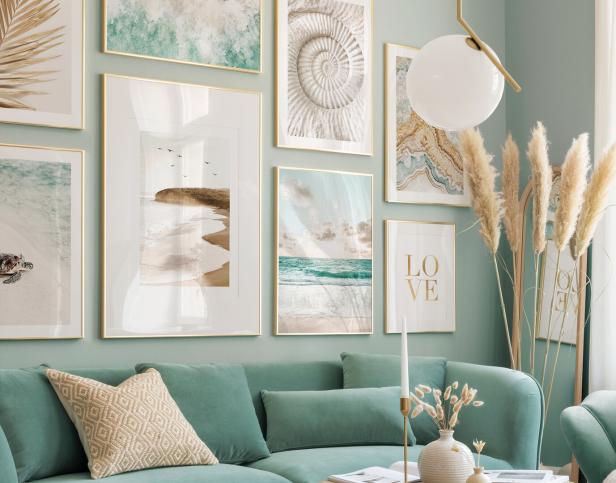 Ein Wohnzimmer mit mintgrünen Wänden und einer Couch mit Küstenmotiven an der Wand.