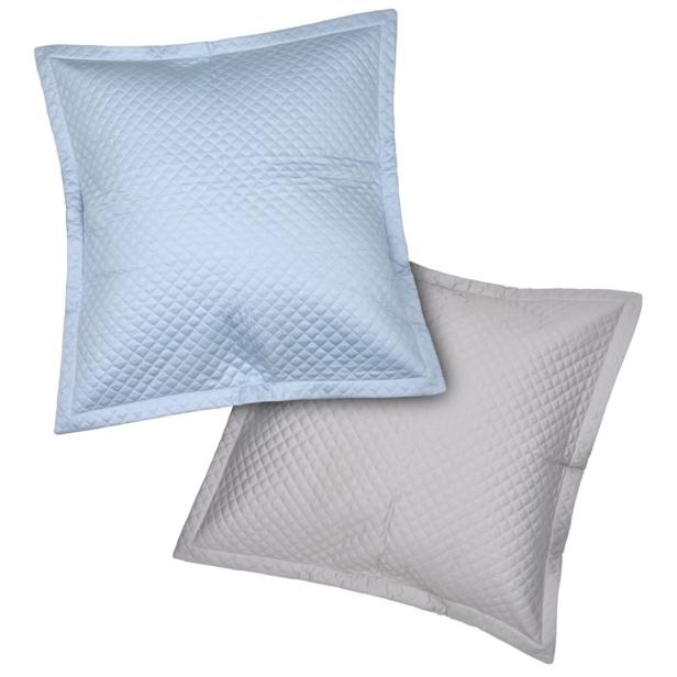 Zwei gesteppte Kissen in Blau und Grau liegen übereinander.