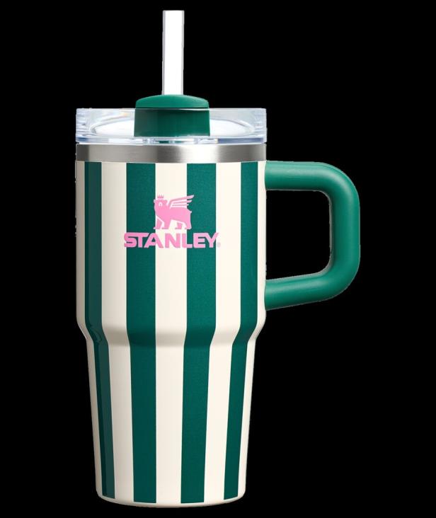 Ein gestreifter Stanley Becher mit Henkel und Strohhalm vor schwarzem Hintergrund.