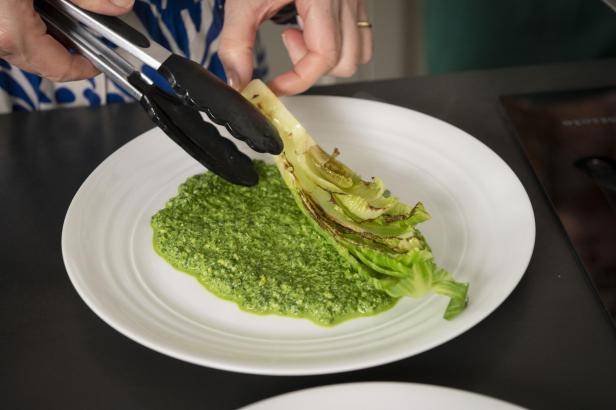 Mangold-Pesto und Romana-Salat auf Teller anrichten