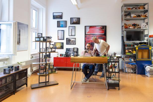 Ein Mann sitzt am Schreibtisch und betrachtet ein Diorama in der Diorama Manufaktur Winkler & Zink.
