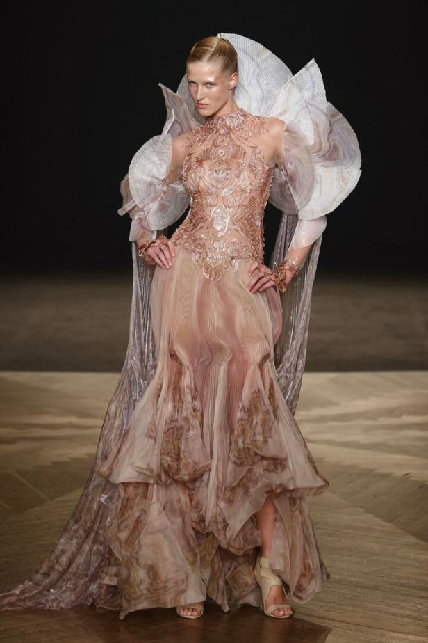 Ein Model präsentiert ein aufwendiges Kleid von Iris van Herpen auf einer Modenschau in Frankreich.