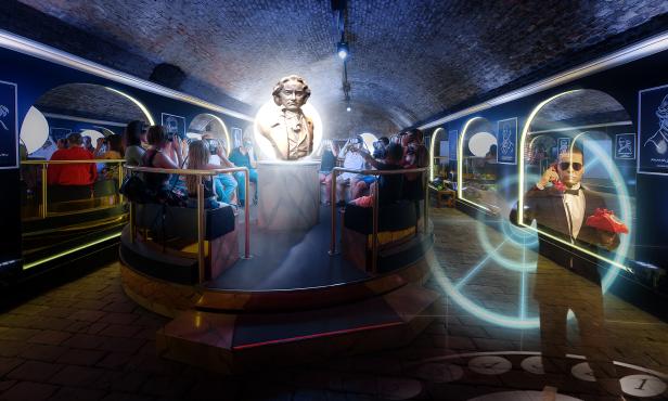 Menschen gehen durch einen Tunnel und sehen Bilder mittels Virtual Reality Brille.