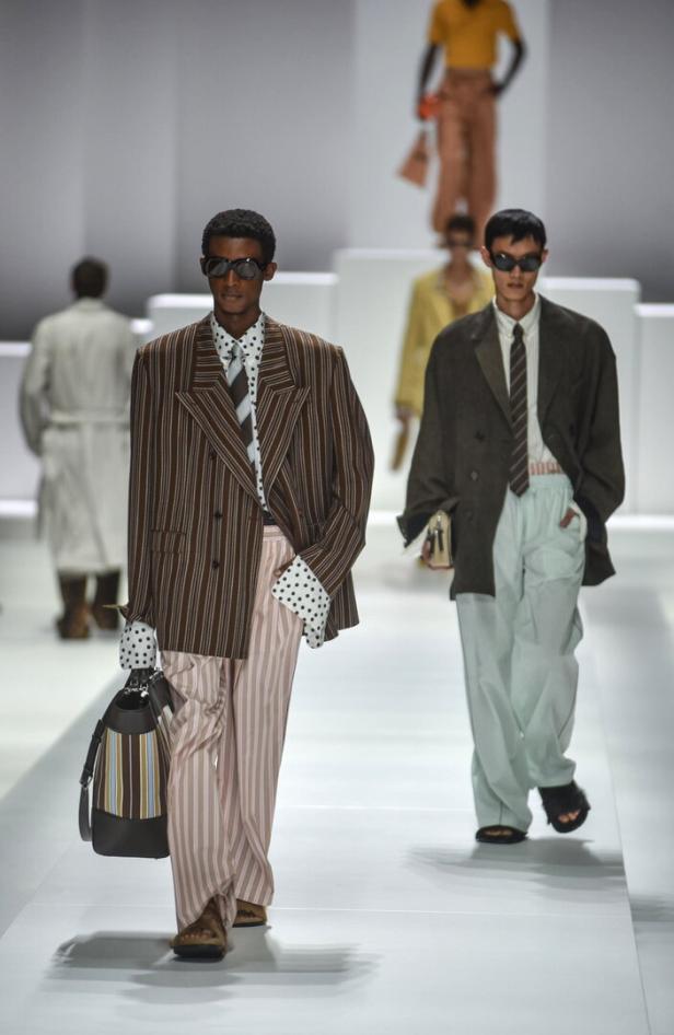 Models präsentieren übergroße Anzüge und gestreifte Hosen auf dem Laufsteg der Mailänder Modewoche SS 2026.