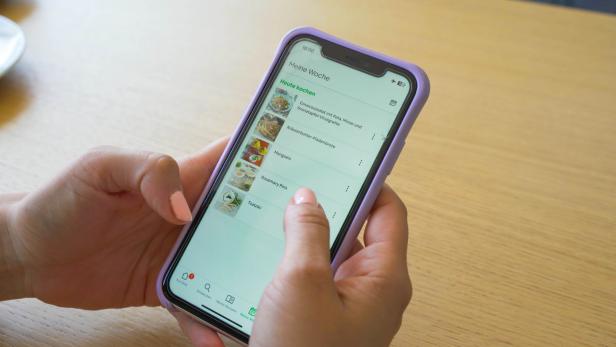 Eine weibliche Hand hält ein Smartphone in der Hand.
