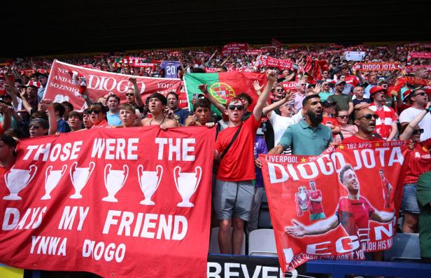 Liverpool-Fans mit Bannern von Diogo Jota während eines Fußballspiels.