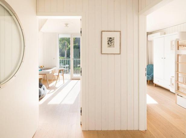 Ein Blick durch zwei offene Türen in ein helles, weißes Haus.