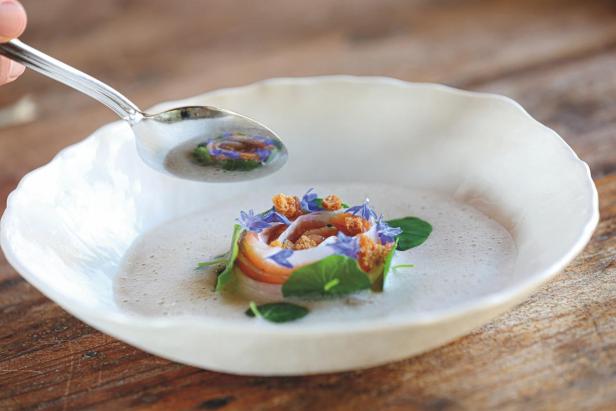Auf dem Bild ist ein Suppenteller mit einer schön angerichteten Suppe zu sehen.