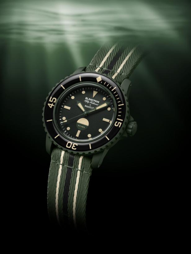 Eine grüne Blancpain x Swatch „Fifty Fathoms“ Taucheruhr mit einem gestreiften Armband.