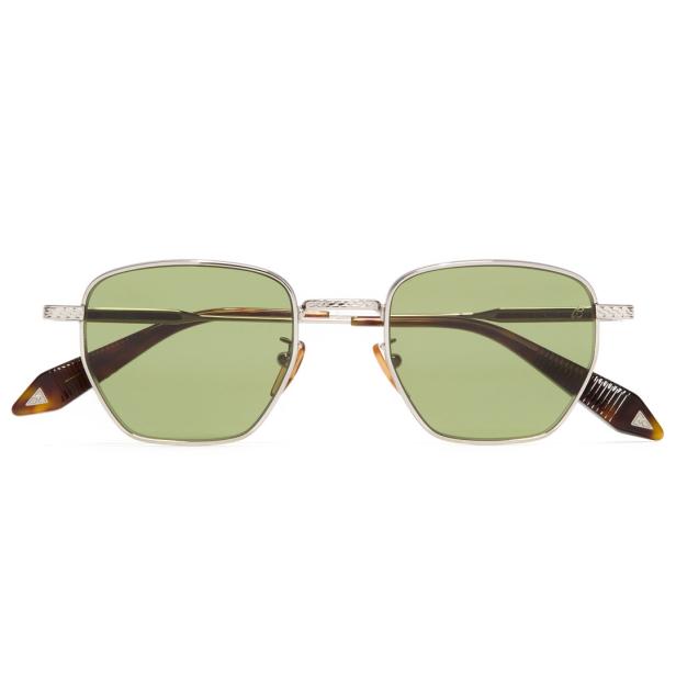 Eine silberne Brille mit grünen Gläsern vor einem weißen Hintergrund.