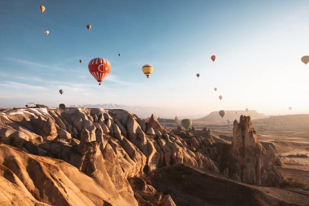 Viele Heißluftballons schweben über der Landschaft von Kappadokien.