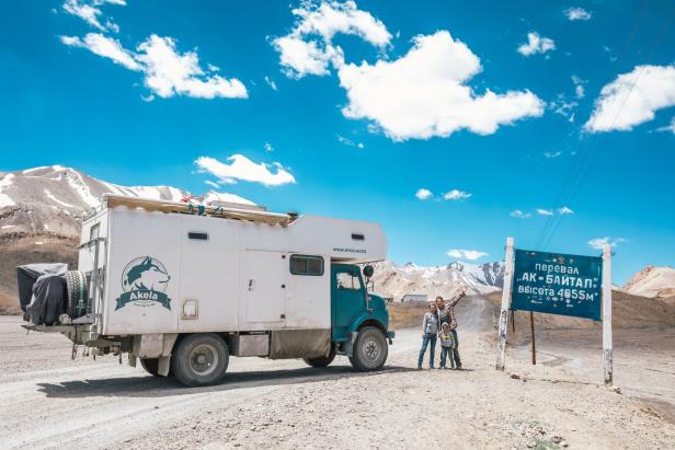 Eine Familie steht vor ihrem Expeditionsmobil am Ak-Baital-Pass in Tadschikistan.