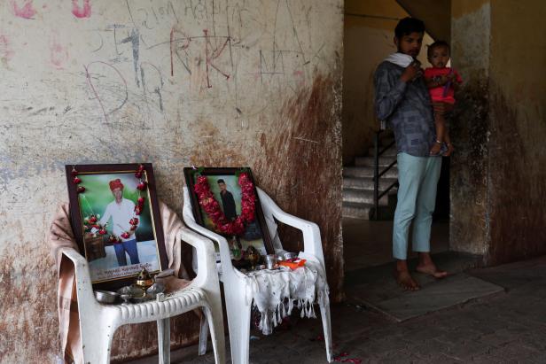 Ein Familienmitglied mit einem Kind steht neben einem Foto von Akash Patni, der nach dem Absturz einer Air India Boeing 787-8 Dreamliner beim Start von einem Flughafen in Ahmedabad ums Leben kam.