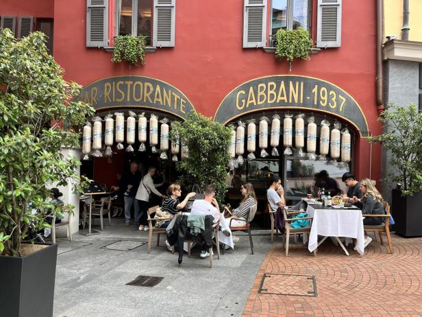 Gäste sitzen vor dem „Bar-Ristorante Gabbani-1937“.