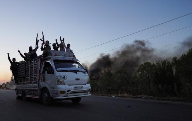 Bedouin fighters ride on a vehicle along a street, at Sweida governorate Bedouin fighters ride on a vehicle along a street, at Sweida governorate