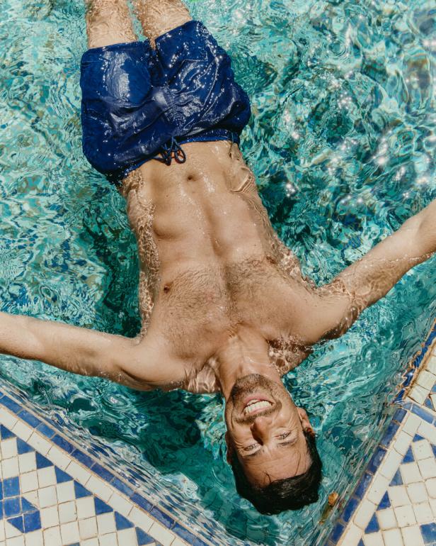 Ein Mann entspannt im türkisfarbenen Wasser eines Schwimmbeckens.