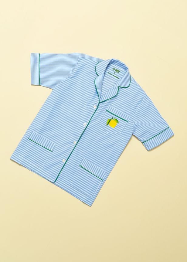 Ein blau-weiß gestreifter Pyjama mit grünen Akzenten und einer aufgestickten Zitrone.