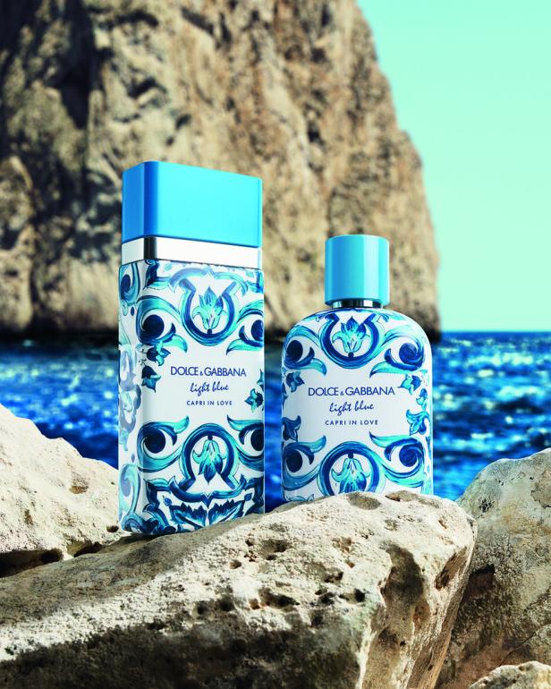 Zwei Flakons des Parfüms „Dolce & Gabbana Light Blue Capri in Love“ stehen auf Felsen am Meer.