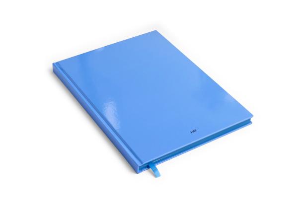 Ein hellblaues Notizbuch der Marke HAY liegt auf einem weißen Hintergrund.