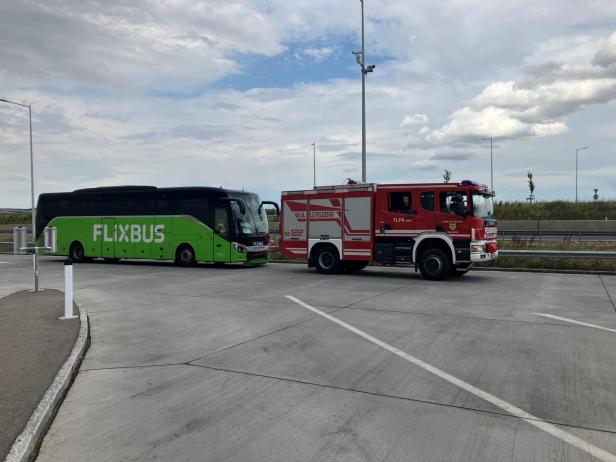 Ein Flixbus steht neben einem roten Feuerwehrauto der Freiwilligen Feuerwehr Wullersdorf.