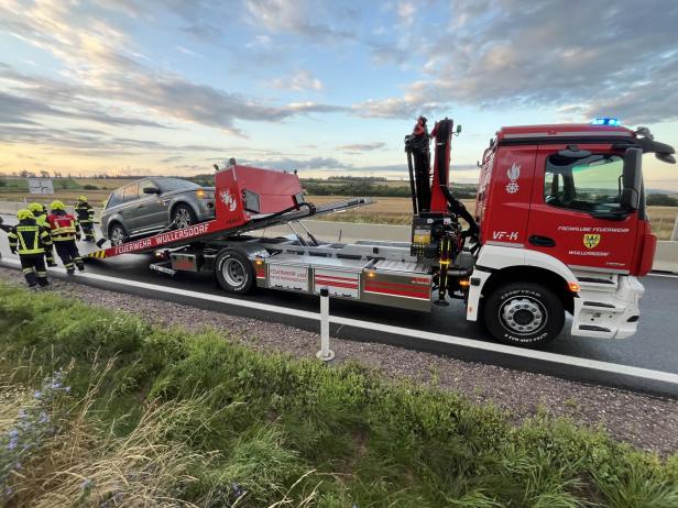 Ein Feuerwehrfahrzeug der Freiwilligen Feuerwehr Wullersdorf transportiert ein Auto.