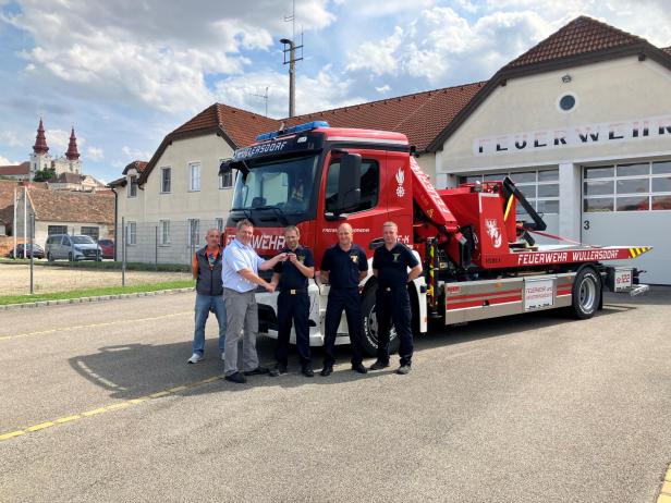 Mitglieder der FF Wullersdorf vor Feuerwehrauto.