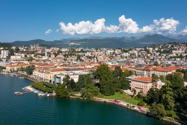 Luftaufnahme von Lugano am Luganersee mit Bergen im Hintergrund.