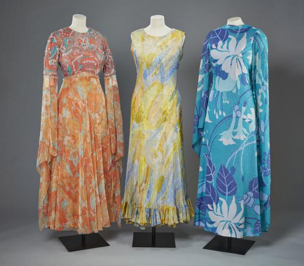 Drei farbenfrohe, gemusterte Kleider aus der „Queen Elizabeth II: Her Life in Style“-Ausstellung im Buckingham Palace 2026.