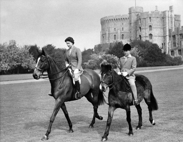 Königin Elizabeth II. und Prinz Charles reiten vor Schloss Windsor.
