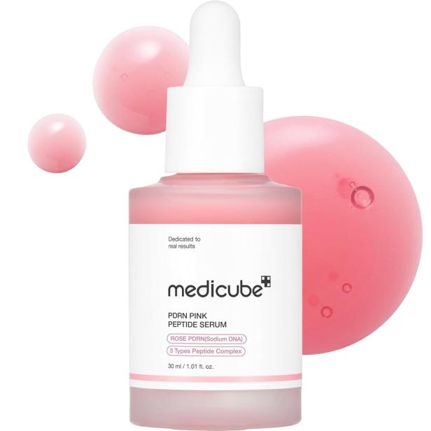 Eine Flasche „Medicube PDRN Pink Peptide Serum“ vor rosa Kugeln.